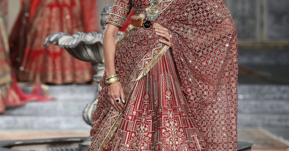 Model in red lehenga at a fashion show in New Delhi, India, showcasing traditional bridal wear.