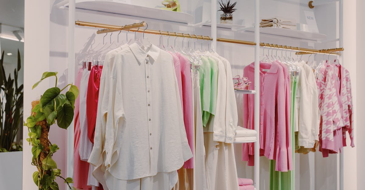 Vibrant fashion ensemble with pink, green, and white garments on store display rack.